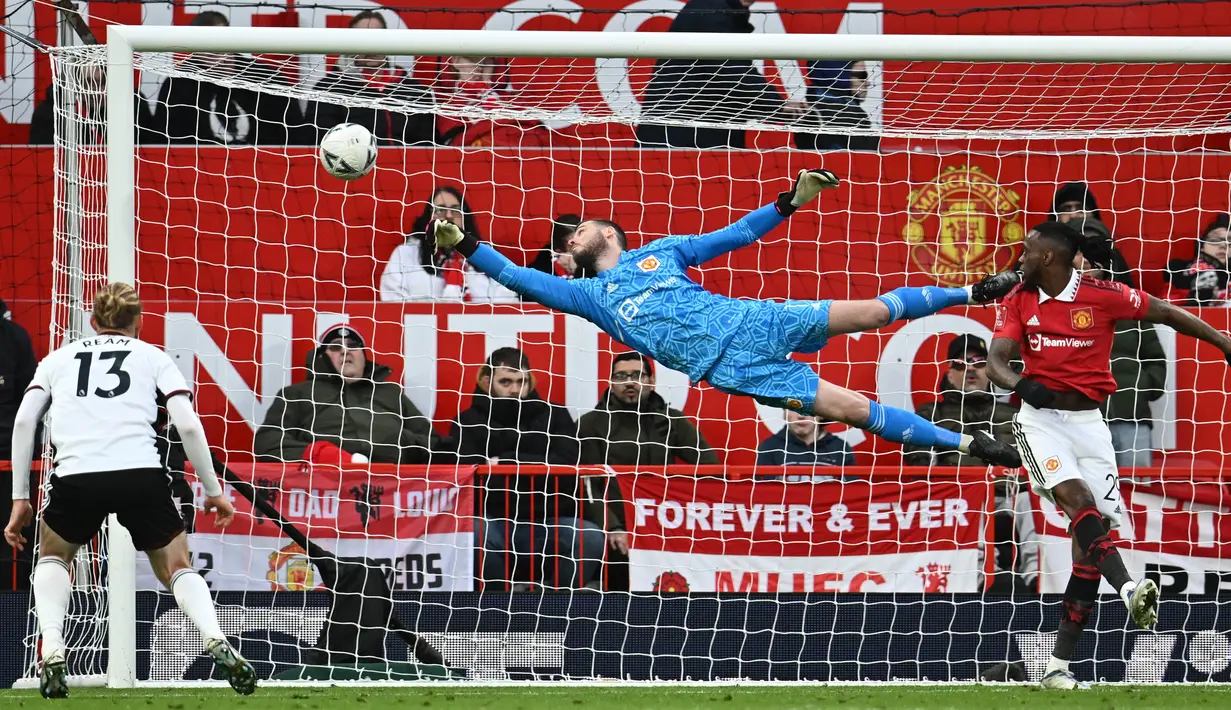 <p>Penjaga gawang Manchester United, David de Gea (tengah), berhasil menghalau tendangan dari pemain Fulham dalam pertandingan yang berlangsung di Old Trafford, Minggu (19/3/2023). (AFP/Paul Ellis)</p>