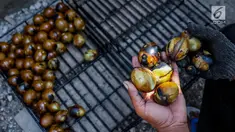 Warga menunjukan telur asin yang telah melalui proses pengasapan di industri rumahan telur asin Cah Angon, Limbangan, Brebes, Jawa Tengah, Minggu (2/7). (Liputan6.com/Faizal Fanani)