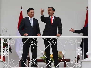 Presiden Joko WIdodo (Jokowi) berbincang dengan PM Republik Demokratik Rakyat Laos Thongloun Sisoulith di beranda Istana Bogor, Jawa Barat, Kamis (12/8). Jokowi menyambut PM Thongloun dengan upacara resmi kenegaraan. (Liputan6.com/Angga Yuniar)