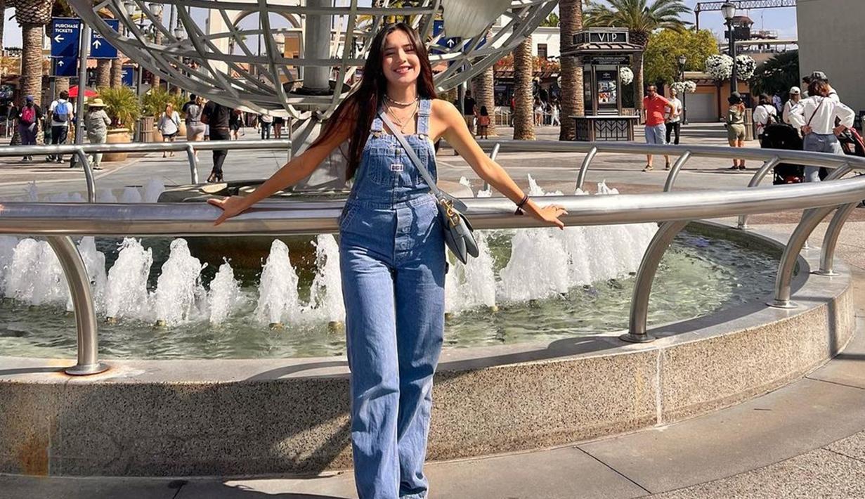 Pada momen spesial bertemu idola, kamu pasti ingin tampil memesona dengan mengenakan outfit stylish. Gaya Beby Tsabina mengenakan overall jeans ini bisa banget disontek. Fashion item yang hits tahun 90-an ini memang kembali tren sekarang. Kesan santai dari outfit ini membuatmu nyaman saat nonton konser. (Liputan6.com/IG/@bebytsabina)