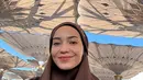 Selain putih, Enzy juga tampil dengan khimar dan abaya coklat saat berada di Madinah. Ia pun tampak berfoto selfie memerlihatkan wajah natural tanpa makeupnya.  [@enzystoria]