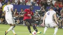 Aksi pemain Manchester United, Romelu Lukaku (tengah) melepaskan tembakan saat diadang dua pemain LA Galaxy pada laga persahabatan di California, Sabtu (15/7/2017).  (AFP/Ringo Chiu)