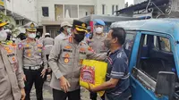 Kapolres Metro Depok memberikan paket sembako kepada pengemudi angkot di Jalan Raya Bogor, Kecamatan Sukmajaya, Kota Depok. (Liputan6.com/Dicky Agung Prihanto)