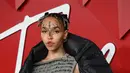 FKA Twigs berpose untuk fotografer setibanya di British Fashion Awards di London, Senin, 5 Desember 2022. Wanita berusia 34 tahun itu menarik perhatian banyak orang dengan penampilannya yang unik, yaitu wajahnya ditutupi bintik-bintik gelap dalam pola melingkar. (AFP/DANIEL LEAL)