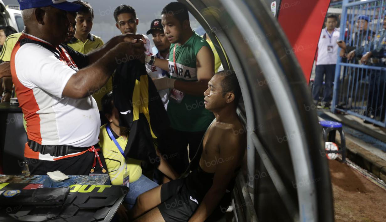 Wasit Oky Dwi Putra Senjaya mengalami sesak napas akibat asap flare memimpin Madura United vs Persiba Balikpapan pada Torabika SC2016 di Stadion Gelora Bangkalan, Senin(13/6/2016).  (Bola.com/Nicklas Hanoatubun)