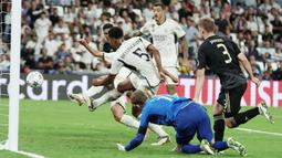 Pemain Real Madrid, Jude Bellingham, mencetak gol ke gawang Union Berlin dalam matchday 1 Grup C Liga Champions 2023/2024, di Stadion Santiago Bernabeu, Madrid, Rabu (20/9/2023). Bellingham menjadi pahlawan berkat gol semata wayangnya. (AFP/Thomas Coex)