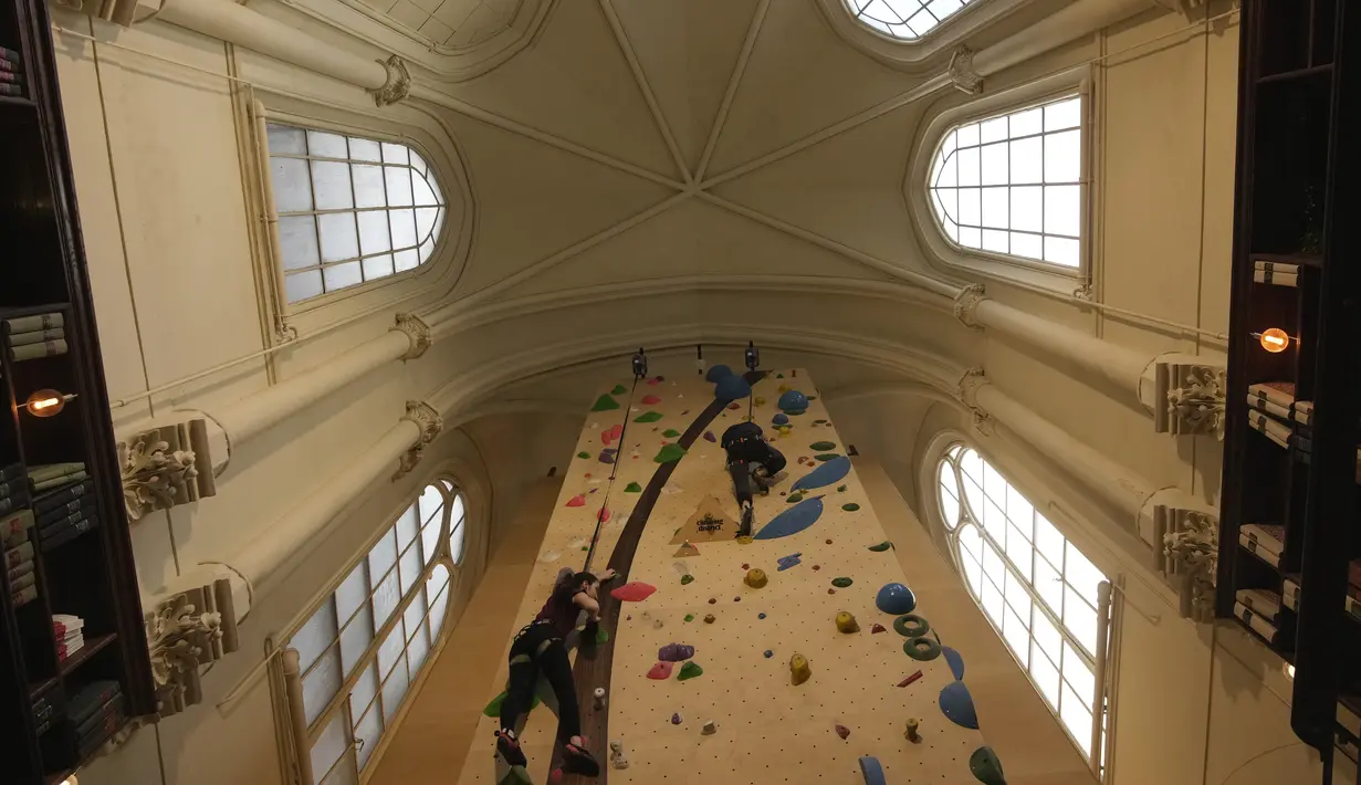 Peserta berlatih memanjat di lokasi Climbing District di Paris, Rabu, 11 Januari 2023. Tembok panjat buatan baru ini dibuka pada November 2022 di dalam bekas kapel abad ke-19, bernama le couvent des Oblats de Marie-Immaculee. (AP Photo/Christophe Ena)