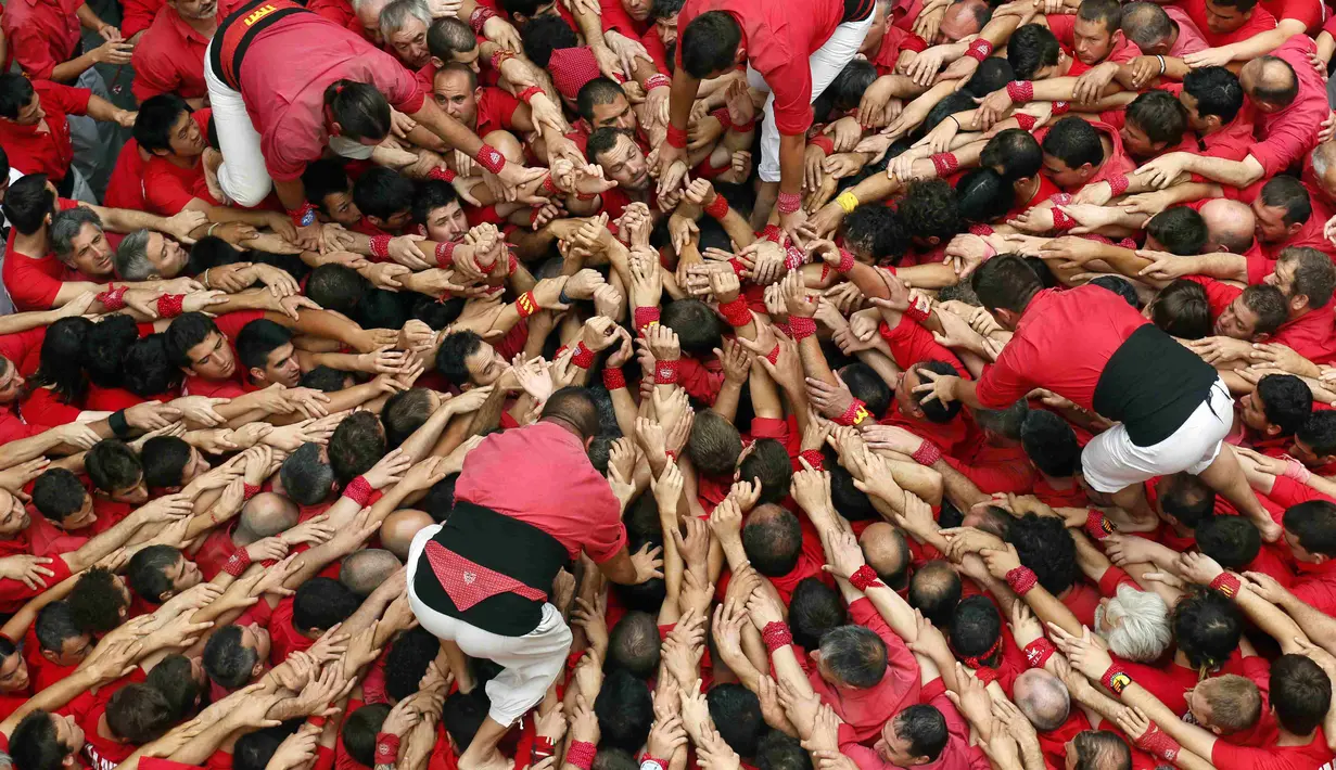Castellers Colla Vella dels Xiquets de Valls saat mulai membentuk dasar menara manusia di festival Sant Joan, Spanyol, Selasa (24/6/14). (REUTERS/Albert Gea)