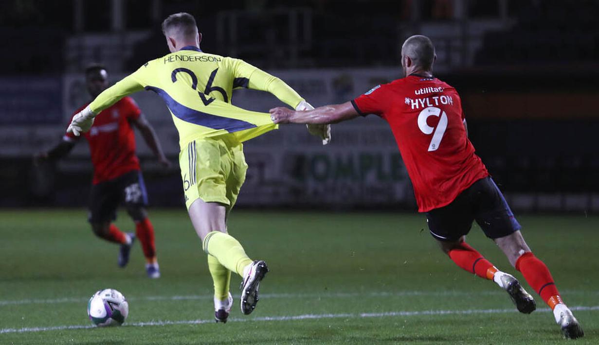 Kiper Manchester United, Dean Henderson, ditarik pemain Luton Town, Danny Hylton, pada Piala Liga Inggris di Stadion Kenilworth Road, Rabu (23/9/2020). Setan Merah menang dengan skor 3-0. (Cath Ivill/Pool via AP)