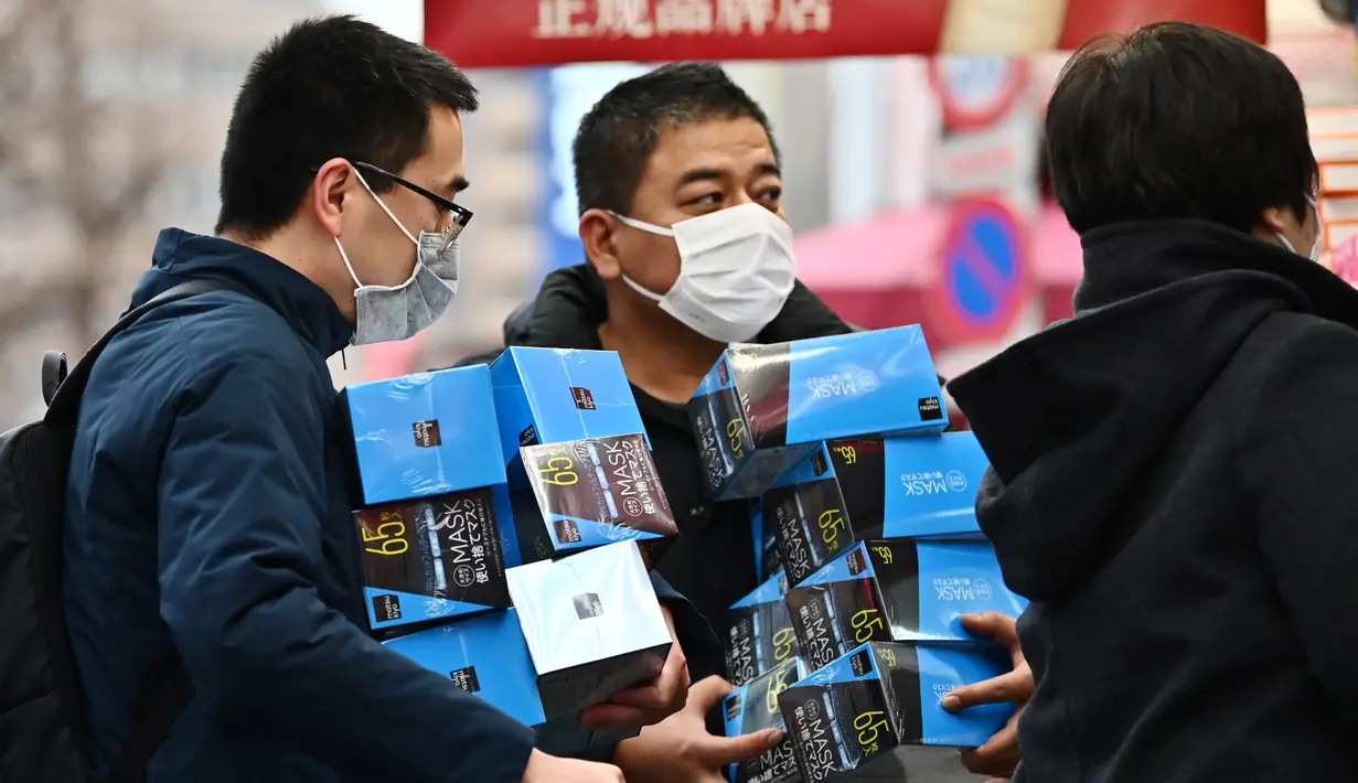 Pelanggan membeli masker dari apotek di daerah Akihabara Tokyo (27/1/2020). Masker dipilih sebagai salah satu tindak pencegahan sederhana dari virus dengan karakteristik mirip SARS tersebut. (AFP Photo/Charly Triballeau)
