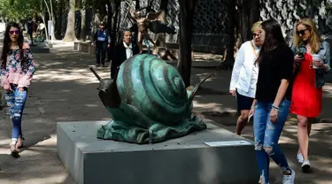 Pengunjung melihat patung "Snail dan Angel" saat pameran "Salvador Dali: Urban Dreams" di Mexico City, Selasa (14/3). Patung-patung tersebut adalah karya seniman asal spanyol yang bernama Salvador Dali. (AFP PHOTO / RONALDO SCHEMIDT)