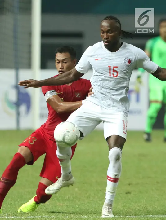 Bek Timnas Indonesia, Hansamu Yama Pranata (kiri) berebut bola dengan pemain Hong Kong, Paul Olivier Ngue pada laga uji coba internasional di Stadion Wibawa Mukti, Cikarang, Selasa (16/10). Laga berakhir imbang 1-1. (Liputan6.com/Helmi Fithriansyah)