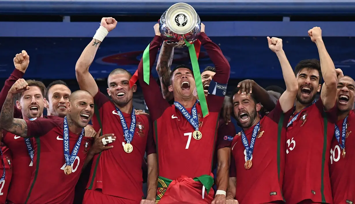 Cristiano Ronaldo akhirnya mengangkat trofi juara Piala Eropa setelah sebelumnya pernah gagal dalam final Piala Eropa 2004 di Stade de France, Saint-Denis, Senin (11/7/2016) dini hari WIB. (AFP/Franck Fife)