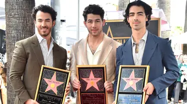 (kiri ke kanan) Kevin Jonas, Nick Jonas, dan Joe Jonas dari Jonas Brothers berpose pada upacara penganugerahan bintang Hollywood Walk of Fame di Los Angeles, Amerika Serikat, 30 Januari 2023. Bintang penghormatan terhadap Jonas Brothers berada di sekitar musikus hebat lainnya seperti Elvis Presley dan The Beatles. (Photo by Jordan Strauss/Invision/AP)