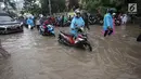 Sejumlah pengendara sepeda motor mendorong kendaraannya saat melintasi banjir di Jalan Boulevard Barat Raya, Kelapa Gading, Jakarta, Kamis (15/2). Hujan lebat yang mengguyur Jakarta mengakibatkan sejumlah wilayah kebanjiran. (Liputan6.com/Arya Manggala)