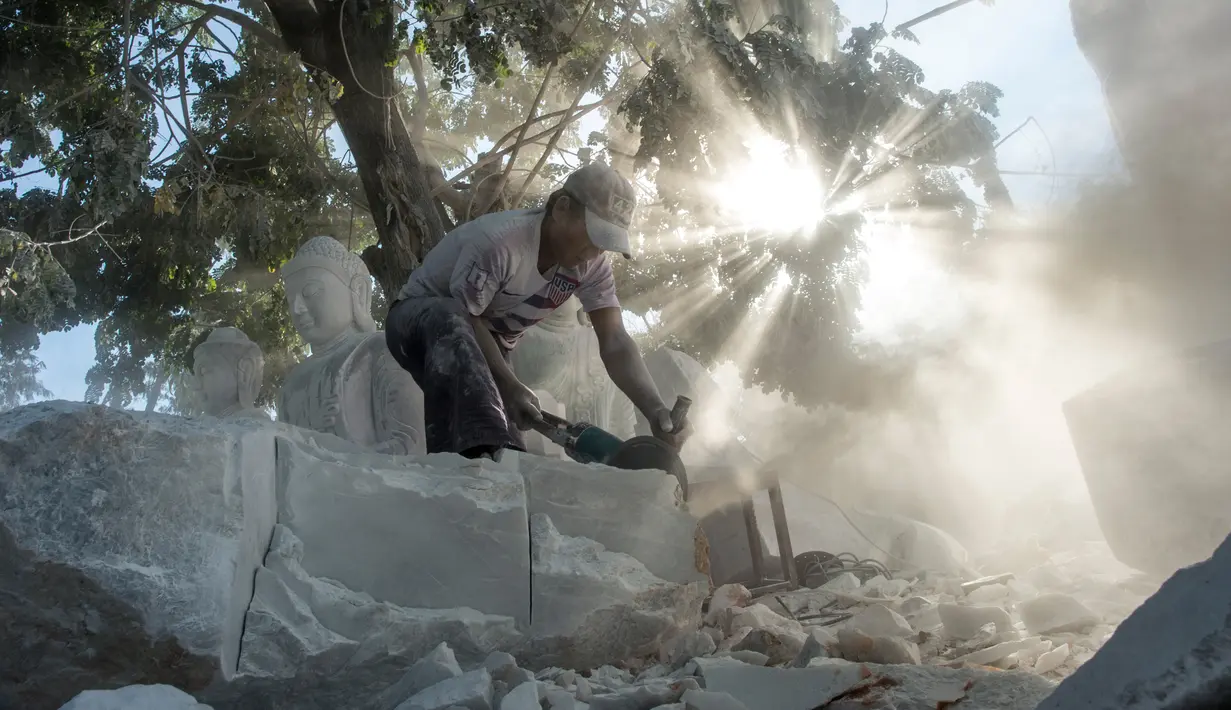 Pekerja memotong balok marmer untuk membuat patung di desa Sagyin, Madaya, Myanmar pada 22 Desember 2018. Desa Zagyin atau biasa disebut Marble ini merupakan tempat terbesar di dunia dalam memproduksi patung Buddha dalam segala ukuran. (YE AUNG THU / AFP)