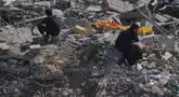 Seorang wanita Palestina yang terpaksa mengungsi duduk di atas puing-puing bangunan yang hancur di kawasan Sheikh Radwan yang parah kerusakannya di Kota Gaza, Sabtu 11 Oktober 2025. (AP Photo/Abdel Kareem Hana)