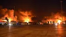 Petugas pemadam kebakaran berjuang melawan kobaran api setelah serangan udara Israel di Pelabuhan Latakia, Suriah, 28 Desember 2021. Serangan udara Israel menghantam Pelabuhan Latakia sekitar pukul 03.21 waktu setempat. (SANA/AFP)