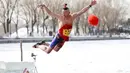 Seorang pria saat melompat ke danau yang beku di Shenyang di provinsi Liaoning, China timur laut (2/3). (AFP Photo)