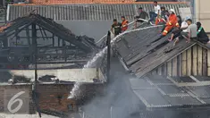 Petugas bersama warga berusaha memadamkan api yang membakar pemukiman penduduk di Jalan Gelora IX A, Palmerah, Jakarta, Kamis (4/8). Api yang diduga berasal dari arus pendek itu membakar 8 rumah. (Liputan6.com/Immanuel Antonius)