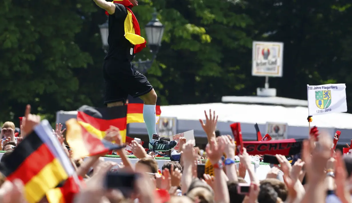 Salah satu aksi penjaga gawang Timnas Jerman, Manuel Neuer, saat perayaan kemenangan Der Panzer di Berlin, (15/7/2014). (REUTERS/Thomas Peter)