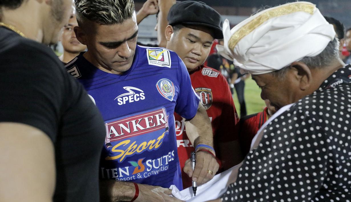 Cristian Gonzales melayani permintaan tanda tangan oleh salah satu fans, dikawal oleh bodyguard seusai bertanding melawan Mitra Kukar, Sabtu (17/10/2015). (Bola.com/Erwin Fitriansyah)
