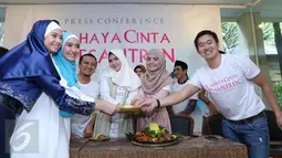 Sejumlah pemain film Cahaya Cinta Pesantren menerima potongan tumpeng saat menggelar konferensi pers, Jakarta, Senin (25/1/2016). Film ini diadaptasi dari novel karya Ira Madan. (Liputan6.com/Herman Zakharia)