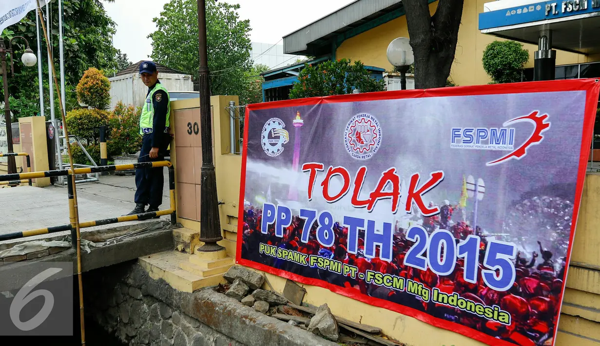 Buruh memasang spanduk di depan gudang pabrik sebagai tanda dukungan pada rekan buruh yang melakukan aksi demo, Jakarta, Selasa (24/11/2015).  Buruh menuntut dicabutnya Peraturan Pemerintah No 78 Tahun 2015 tentang Pengupahan. (Liputan6.com/Yoppy Renato)