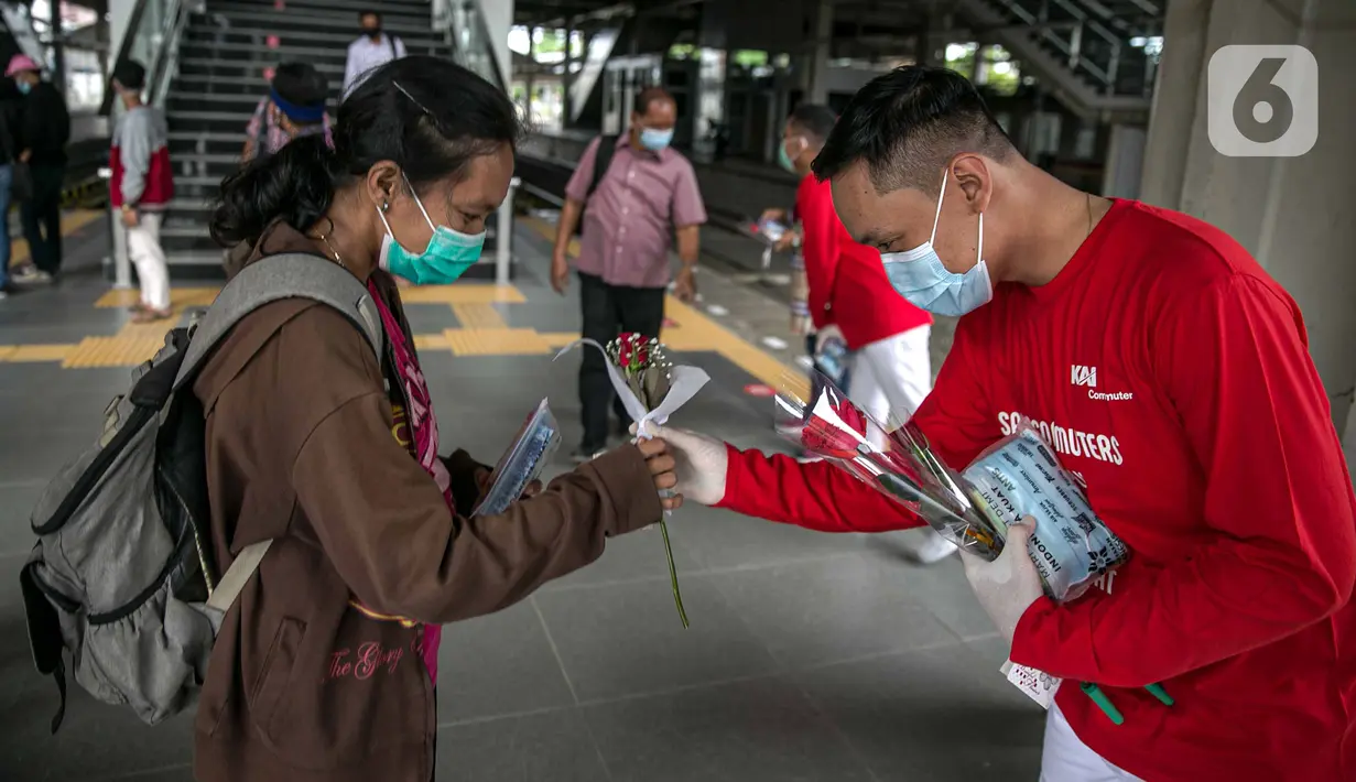 Petugas KAI Commuter (kanan) memberikan bunga dan healthy kit kepada perempuan pengguna KRL di Stasiun Jatinegara, Jakarta, Selasa (22/12/2020). Kegiatan tersebut dalam rangka memperingati Hari Ibu yang jatuh setiap tanggal 22 Desember. (Liputan6.com/Faizal Fanani)
