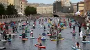 Suasana sejumlah peserta yang mengenakan kostum mendayung papan Stand Up Paddle (SUP) mereka di kanal Kryukov saat Surfing festival di St.Petersburg, Rusia (8/7). Olahraga ini menjadi sangat populer sejak tahun 2005. (AP Photo / Dmitri Lovetsky)