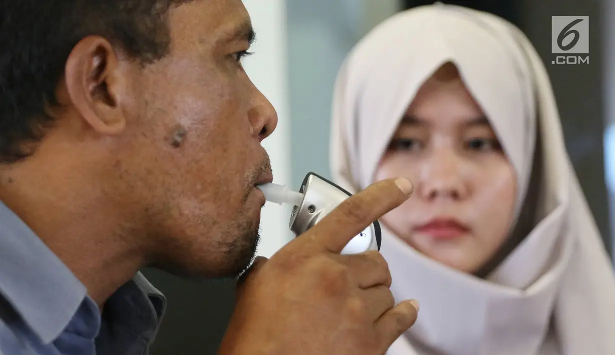 Sopir bus Antar Kota Antar Provinsi (AKAP) menjalani tes kesehatan dengan meniup "Alcohol Detector" di Terminal Pulo Gebang, Kamis (22/6). Tes ini bertujuan memberikan rasa aman kepada penumpang selama perjalanan mudik. (Liputan6.com/Immanuel Antonius)