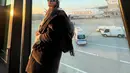 Gaya airport Camelia Putri yang sporty dan trendi. Dengan trench coat dan aksesori topi. [Foto: @cameliaputricp]