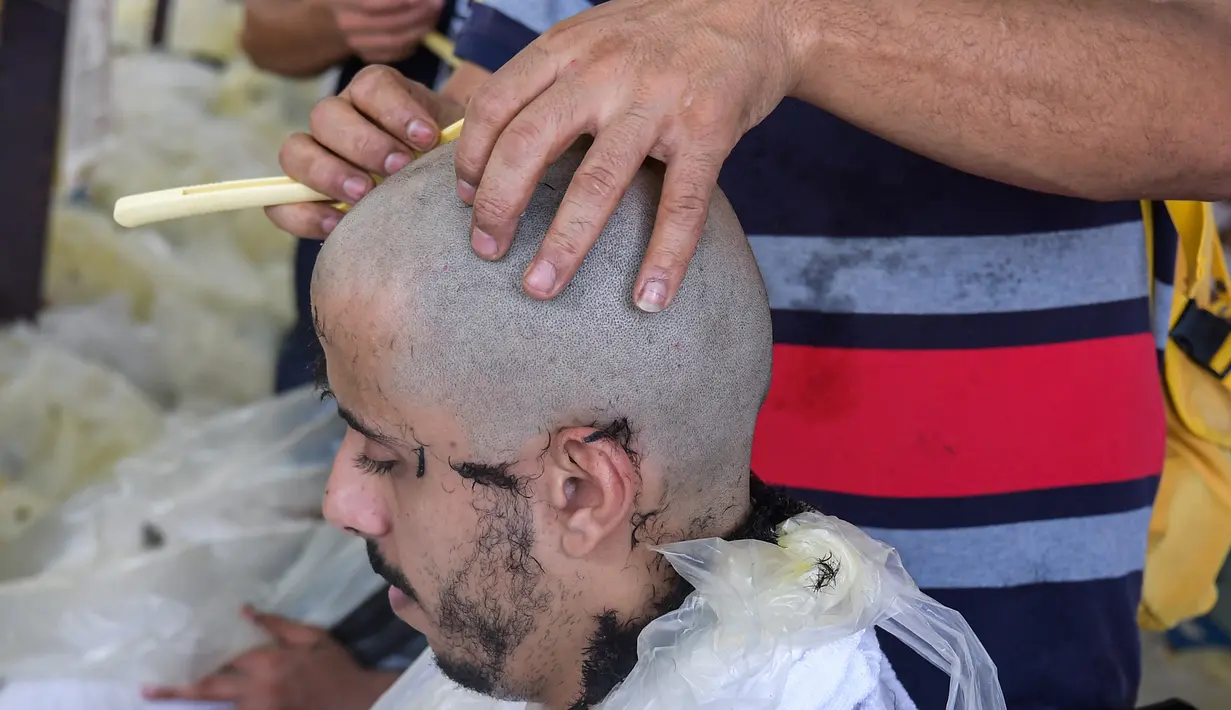Jemaah haji mencukur rambut kepala atau tahalul usai melaksanakan lempar jumrah, Mina, Arab Saudi, Minggu (11/8/2019). Tahalul dilakukan sekurang-kurangnya setelah lewat tanggal 10 Zulhijah. (FETHI BELAID/AFP)