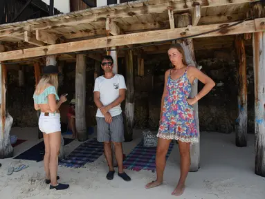 Turis Ukraina terlihat di pantai sebuah hotel di Zanzibar (3/3/2022). Tanzania mengatakan akan menjaga ratusan turis Ukraina yang terdampar di kepulauan Zanzibar di Samudera Hindia setelah Ukraina menutup wilayah udaranya untuk penerbangan sipil menyusul invasi Rusia. (AFP/Ericky Boniphace)