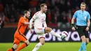 Pemain Denmark Christian Eriksen (tengah) berebut bola dengan pemain Belanda Daley Blind (kiri) disaksikan wasit Lawrence Visser dari Belgia pada pertandingan persahabatan di Johan Cruyff ArenA, Amsterdam, Belanda, 26 Maret 2022. Belanda menang 4-2. (AP Photo/Peter Dejong)
