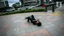 Warga terjatuh saat bermain skateboard di trotoar Jalan Sudirman-Thamrin, Jakarta, Jumat (5/3/2021). Gubernur DKI Jakarta Anies Baswedan mengizinkan trotoar untuk digunakan sebagai tempat bermain skateboard dengan beberapa kesepakatan. (Liputan6.com/Faizal Fanani)