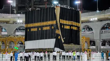 Kiswah baru, atau kain hitam dipasangkan di situs paling suci Islam, Ka'bah di Mekah (29/7/2020). Kiswah adalah kain hitam dengan bordir emas yang menutupi Ka'bah di Makkah, Saudi Arabia diganti setiap tahun selama ibadah haji menjelang perayaan Idul Adha. (Saudi Media Ministry via AP)