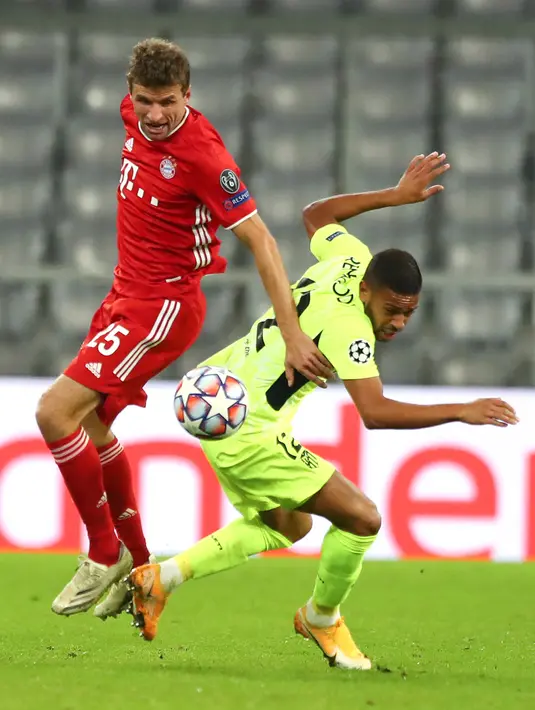 Penyerang Bayern Munchen, Thomas Müller dan bek Atletico Madrid, Renan Lodi berebut bola pada matchday pertama Grup A Liga Champions di Allianz Arena, Kamis (22/10/2020) dini hari WIB. Bayern Munchen berhasil mencukur Atletico Madrid dengan skor 4-0. (AP Photo/Matthias Schrader,Pool)