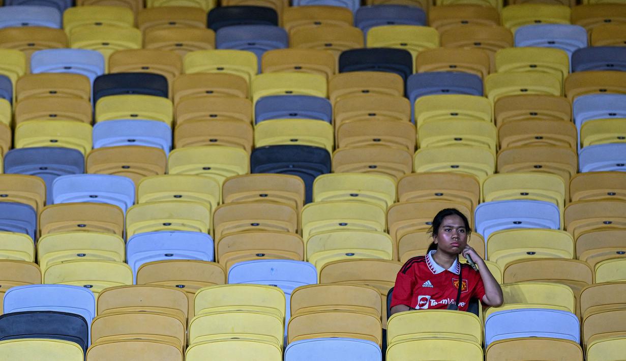 Seorang fans Manchester United duduk di tribune yang kosong dalam laga persahabatan melawan ASEAN All-Stars yang berlangsung di Stadion Bukit Jalil, Malaysia, pada hari Rabu (28/5/2025) malam waktu setempat. (AFP/Mohd Rasfan)