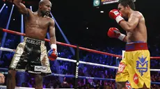 Mayweather Jr. tengah mengambil mengalihkan perhatian Pacquiao dengan mengangkat tangannya. (AP Photo/John Locher)