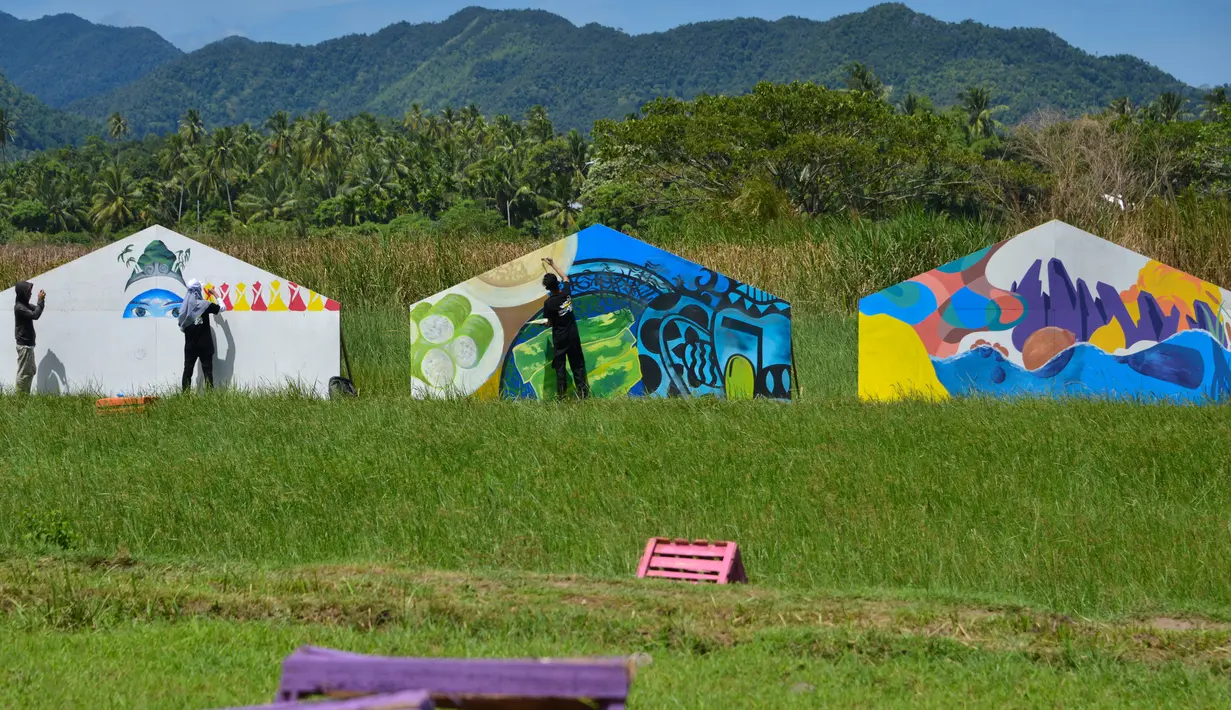 Pelukis mural dari berbagai komunitas seni menyemarakkan The Art of Color Sensation 2019 di Gampong Nusa, Lhoknga, provinsi Aceh, Minggu (16/6/2019). Mereka mengekspresikan diri membuat lukisan dengan nuansa keindahan alam Gampong Nusa sebagai satu desa wisata di Aceh. (CHAIDEER MAHYUDDIN/AFP)