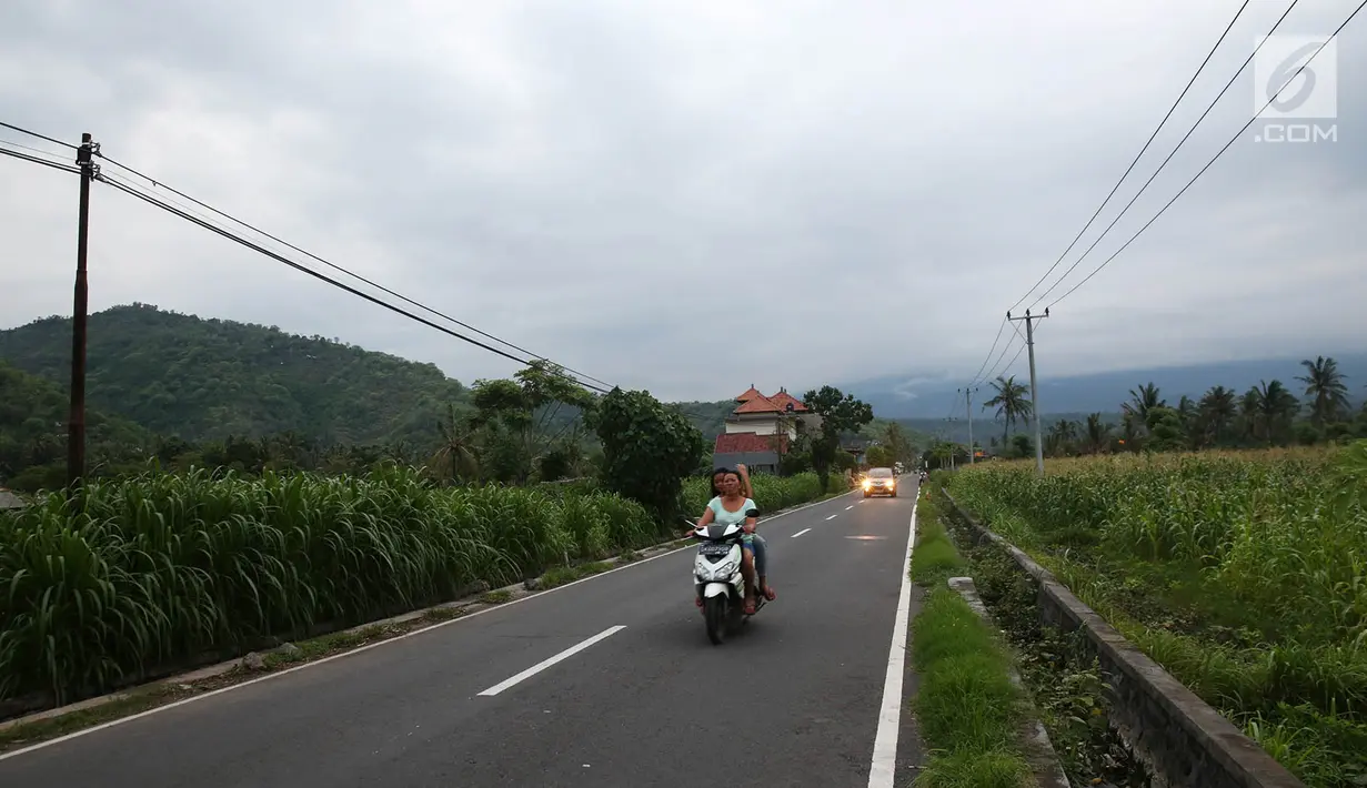 Pengendara melintasi jalanan di kawasan Amed, Karangasem, Bali yang sepi, Selasa (5/12). Erupsi Gunung Agung membuat sektor pariwisata di Pulau Dewata, terutama wilayah Amed sepi dari wisatawan lokal maupun mancanegara. (Liputan6.com/Immanuel Antonius)