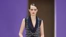 Potret busana Chanel Haute Couture Spring/Summer 2022 berikut bisa dijadikan inspirasi model baju pesta yang elegan dan mewah. Gaun warna hitam dengan detail bukaan di bagian depan ini dipadukan vest chanel berbahan tweed. Stylish dan catchy! (Dok/Chanel).