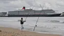 Seorang pria memancing saat kapal Pesiar MS Queen Victoria meninggalkan pelabuhan di La Rochelle, Prancis, 10 April 2018. MS Queen Victoria merupakan sebuah kapal pesiar yang dioperasikan oleh Cunard Line. (AFP PHOTO / XL / XAVIER LEOTY)