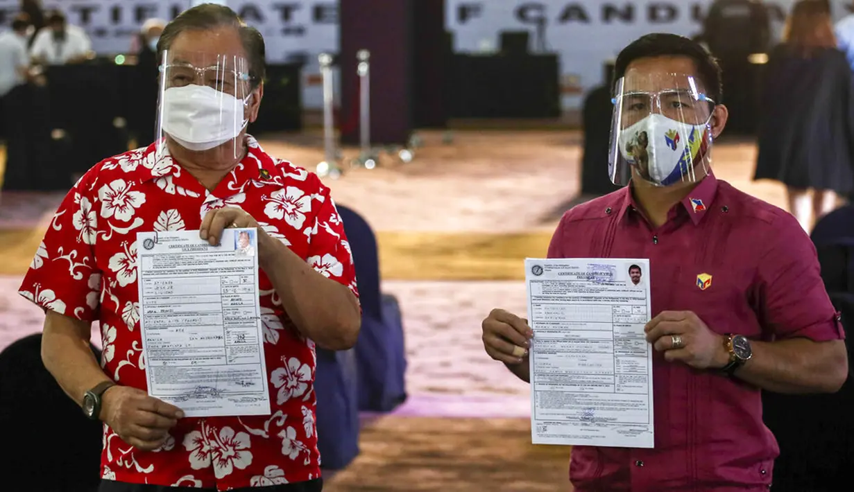 Calon presiden pensiunan bintang tinju Filipina Manny Pacquiao (kanan) dan calon presiden mantan Wali Kota Manila Lito Atienza menunjukkan sertifikat pencalonan mereka untuk pemilihan tahun depan di Sofitel Harbor Garden Tent, Manila, Filipina, Jumat (1/10/2021). (Jam Sta Rosa/Pool Photo via AP)