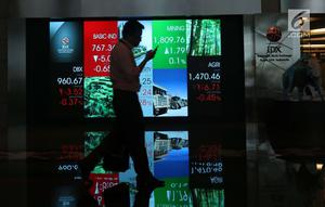 Pekerja melintasi layar pergerakan Indeks Harga Saham Gabungan (IHSG) di BEI, Jakarta, Rabu (16/5). Meski terjebak di zona merah, IHSG berhasil mengakhiri perdagangan di level 5.841. (Liputan6.com/Angga Yuniar)