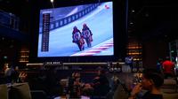 Acara Red Bull MotoGP Rookies Cup 2025 Watch Party yang diselenggarakan di Fatmawati, Jakarta Selatan. Terlihat pada layar, Veda Ega Pratama (54) sedang berduel dengan Brian Uriarte (51) memperebutkan posisi satu balapan. (Liputan6.com/Deniz Akbar)