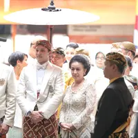 Turun dari mobil, pembalap yang kini menjadi Anggota DPR berusia 34 tahun itu diapit oleh kedua orangtuanya. Puluhan orang sebagai pengiring mengantarkan dengan pakaian senada. Tidak ada kata terucap dari mulut Moreno. (Adrian Putra/Bintang.com)