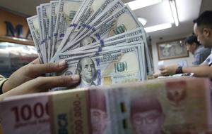 Teller menunjukkan uang dolar dan rupiah di penukaran uang di Jakarta, Junat (23/11). Nilai tukar dolar AS terpantau terus melemah terhadap rupiah hingga ke level Rp 14.504. (Liputan6.com/Angga Yuniar)