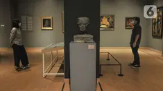 Pengunjung mengamati salah satu karya di Ruang Pameran Tetap, Galeri Nasional Indonesia Jakarta, Kamis (28/10/2021). Galeri Nasional kembali membuka kunjungan publik mulai hari ini seiring penyesuaian PPKM Level 2 dengan menerapkan protokol kesehatan yang ketat. (merdeka.com/Iqbal S Nugroho)